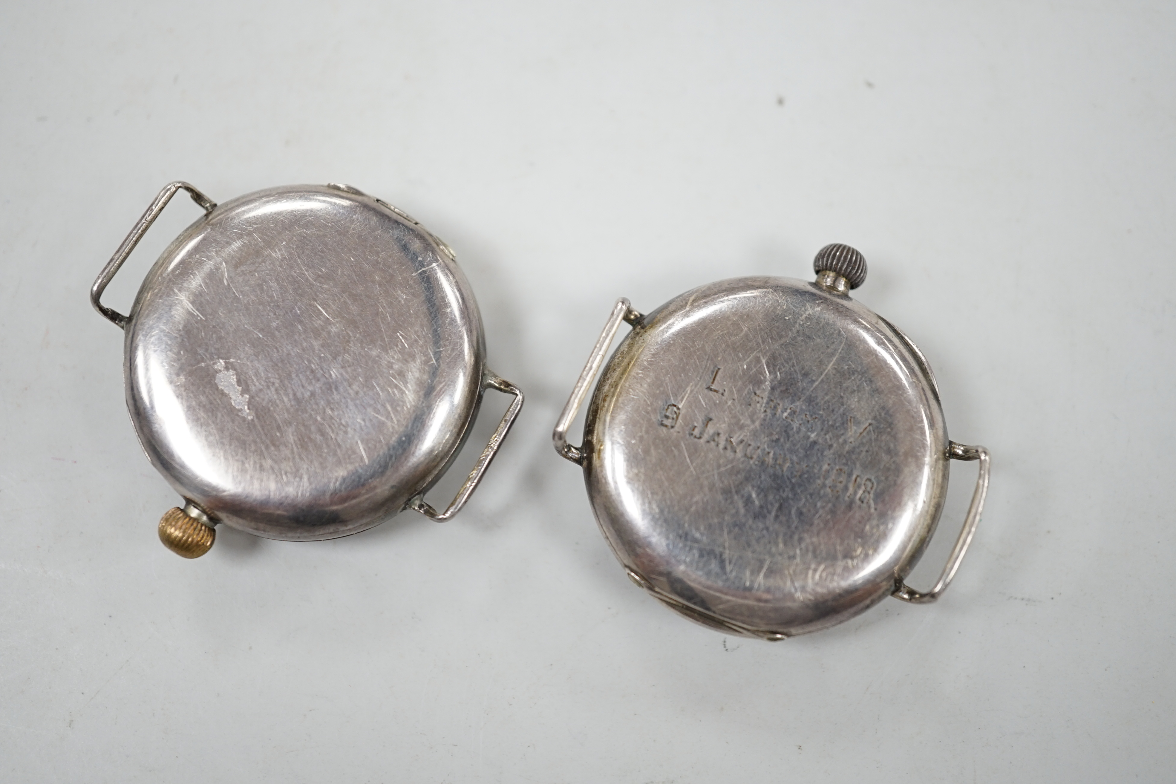 Two early 20th century silver manual wind wrist watches including black dial, both with subsidiary seconds, no straps.